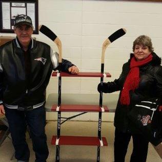 Two seniors posing with hockey sticks